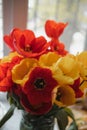 Huge spring colorful bouquet of red and yellow tulips in vase with light classic interior design background. Gift for holiday, bir Royalty Free Stock Photo