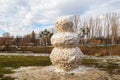 Huge spring snowman in melted meadow. Background with copy space for lettering or text Royalty Free Stock Photo