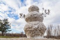 Huge spring snowman in melted meadow. Background with copy space for lettering or text Royalty Free Stock Photo