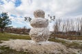 Huge spring snowman in melted meadow. Background with copy space for lettering or text Royalty Free Stock Photo