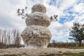 Huge spring snowman in melted meadow. Background with copy space for lettering or text Royalty Free Stock Photo