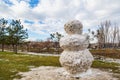 Huge spring snowman in melted meadow. Background with copy space for lettering or text Royalty Free Stock Photo