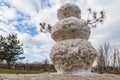 Huge spring snowman in melted meadow. Background with copy space for lettering or text Royalty Free Stock Photo