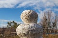 Huge spring snowman in melted meadow. Background with copy space for lettering or text Royalty Free Stock Photo