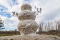 Huge spring snowman in melted meadow. Background with copy space for lettering or text Royalty Free Stock Photo