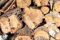 Huge stack of brown firewood made from trees settled at the yard in the village