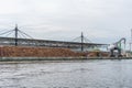 Huge stacks of tree trunks lie in a transshipment port and are loaded by a large crane