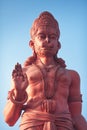 Huge statue of red Hanuman with the raised hand