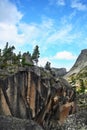 Huge stone block with pines and fir trees on sky