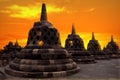 Huge stone Buddhist stupas against the background of a beautiful orange sunrise in the Borobudur Temple. Indonesia. Java island. Royalty Free Stock Photo