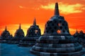 Huge stone Buddhist stupas against the background of a beautiful orange sunrise in the Borobudur Temple.  Indonesia. Royalty Free Stock Photo