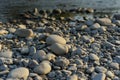 Huge stones on the river bank. River stones and clean, clear water of the river. Pebble stones on the shore are close in Royalty Free Stock Photo