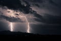 Huge storm over distant mountains with bolts of lightning flashing across the sky Royalty Free Stock Photo