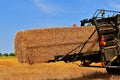A huge straw bale leaves the baler chute Royalty Free Stock Photo