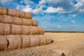 Huge straw pile of Hay roll bales on among harvested field. cattle bedding