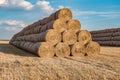 Huge straw pile of Hay roll bales on among harvested field. cattle bedding