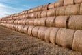 Huge straw pile of Hay roll bales on among harvested field. cattle bedding