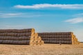 Huge straw pile of Hay roll bales on among harvested field. cattle bedding