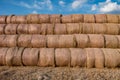 Huge straw pile of Hay roll bales on among harvested field. cattle bedding