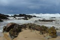 Breaking wave near shoreline with rocky foreground Royalty Free Stock Photo