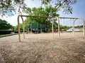 Huge swings with colorful plastic eggs on mulch ground for kids Easter egg hunt activity at large playground with oak trees near Royalty Free Stock Photo