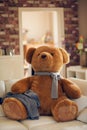 Huge teddy bear is sitting on the couch Royalty Free Stock Photo