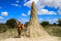 Huge termites hill anthill in Africa, Namibia. A young white girl tourist backpacket stands nearby and shows how huge the termit