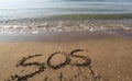 Big text SOS on the sand of the beach Royalty Free Stock Photo