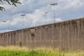 Huge thick high rise wall, tall pole lamps to light the place, wild green grass