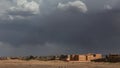 A huge thundercloud is approaching a small Arab city in the desert Royalty Free Stock Photo