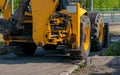 Huge tractor wheels, grader on the side of the city street