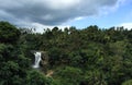 Huge waterfall in tropical forest. Bright exotic nature with fresh water stream.