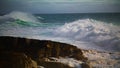 Huge waves breaking rocky beach in super slow motion. Powerful sea surf rolling Royalty Free Stock Photo