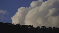 Huge white clouds are moving fast in the mountains.