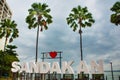 Huge white letters that says I love Sandakan and palm trees. Borneo, Sabah, Malaysia