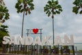 Huge white letters that says I love Sandakan and palm trees. Borneo, Sabah, Malaysia