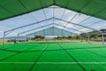 Huge white tent with green floor in field