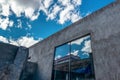 Huge window of a industrial building or depot above the blue sky with plufy clouds