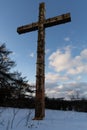 wooden cross on the top of the hill in winter in snow, vetical shot