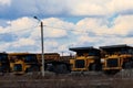 Huge yellow dump trucks on parking near quarry