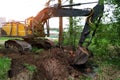 A huge yellow excavator is digging with a bucket in the open air.Preparatory work is underway and a trench is being dug Royalty Free Stock Photo