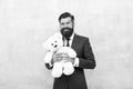 Huggably soft and ideal for cuddling. Happy businessman hold teddy bear toy blue background. Bearded man smile with soft