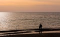 A hugging couple on a sunset background over the sea. Royalty Free Stock Photo