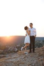 Hugging couple on sunset hill