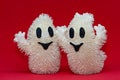 Hugging funny ghosts decoration against red background