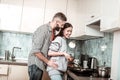 Loving husband hugging his girlfriend cooking breakfast for him Royalty Free Stock Photo