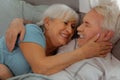 Close-up of husband and wife hugging and lying in bed.