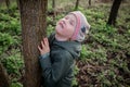 Hugging a tree: the girl feels calm and harmonious, enjoying forest therapy that energizes and restores the soul