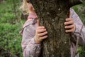 Hugging a tree: the girl feels calm and harmonious, enjoying forest therapy that energizes and restores the soul