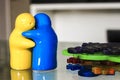 Hugging yellow salt and blue pepper shaker next to multi colour rubber coasters Royalty Free Stock Photo